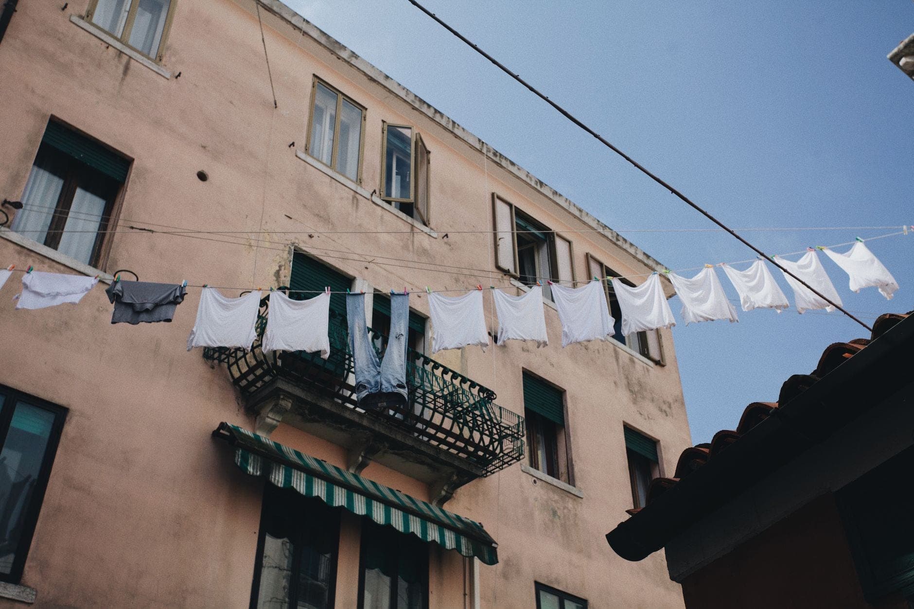 White towels drying on a rail in a sunlit laundry room