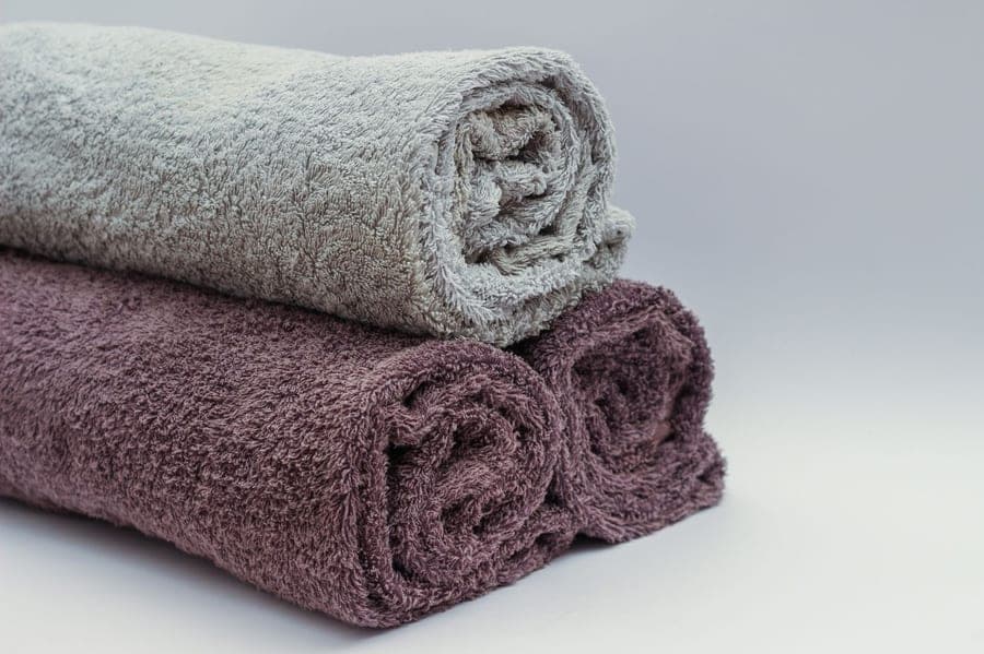 Laundry powder and folded towels on a laundry counter
