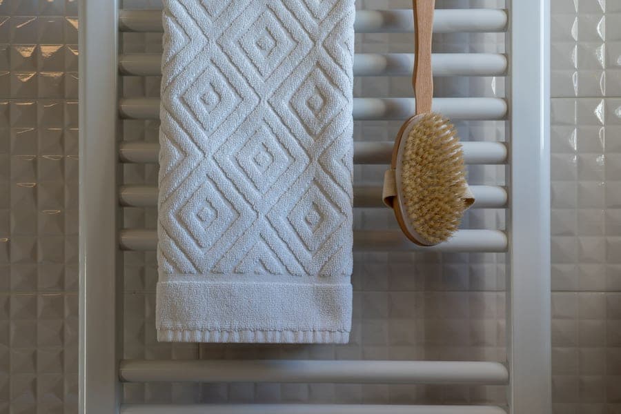 Thick white cotton bath rug on a bathroom floor